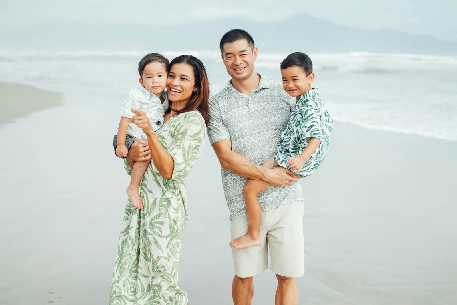 Asian family standing together on a beach