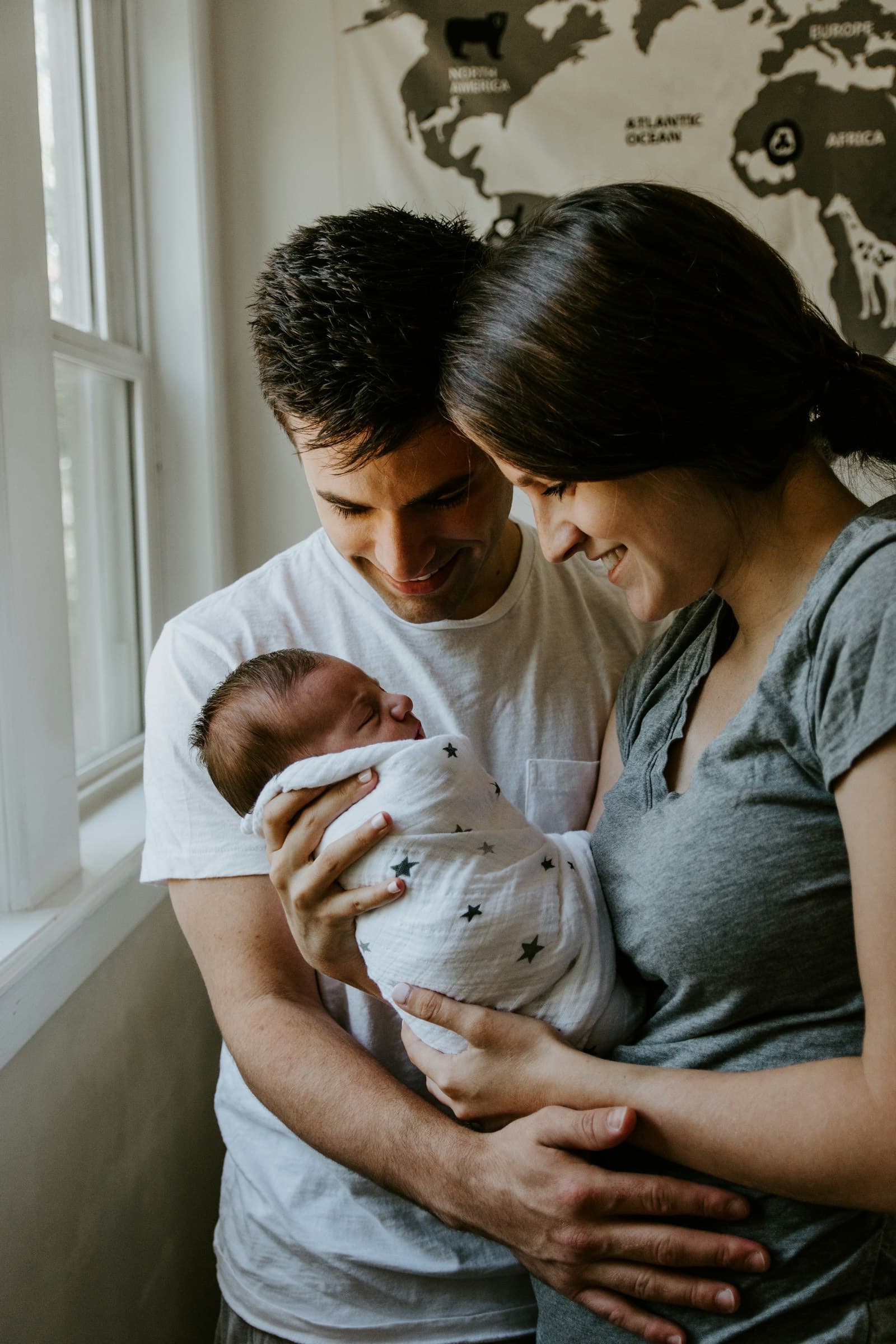 Indian parents holding their baby and smiling